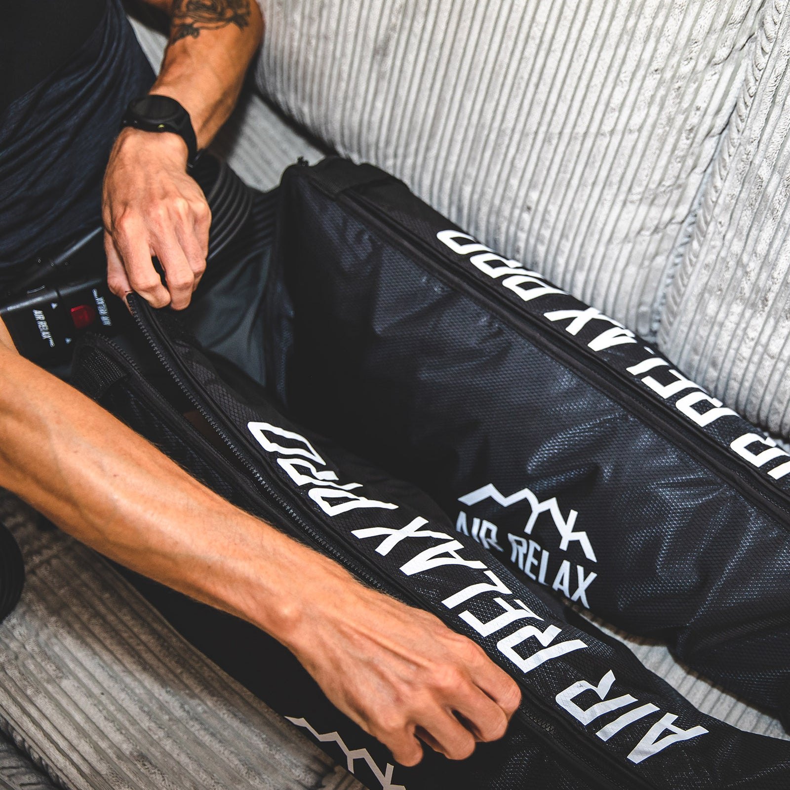 AIR RELAX PRO AR-4.0 LEG SLEEVES — Close-up of hand zipping up the leg sleeves