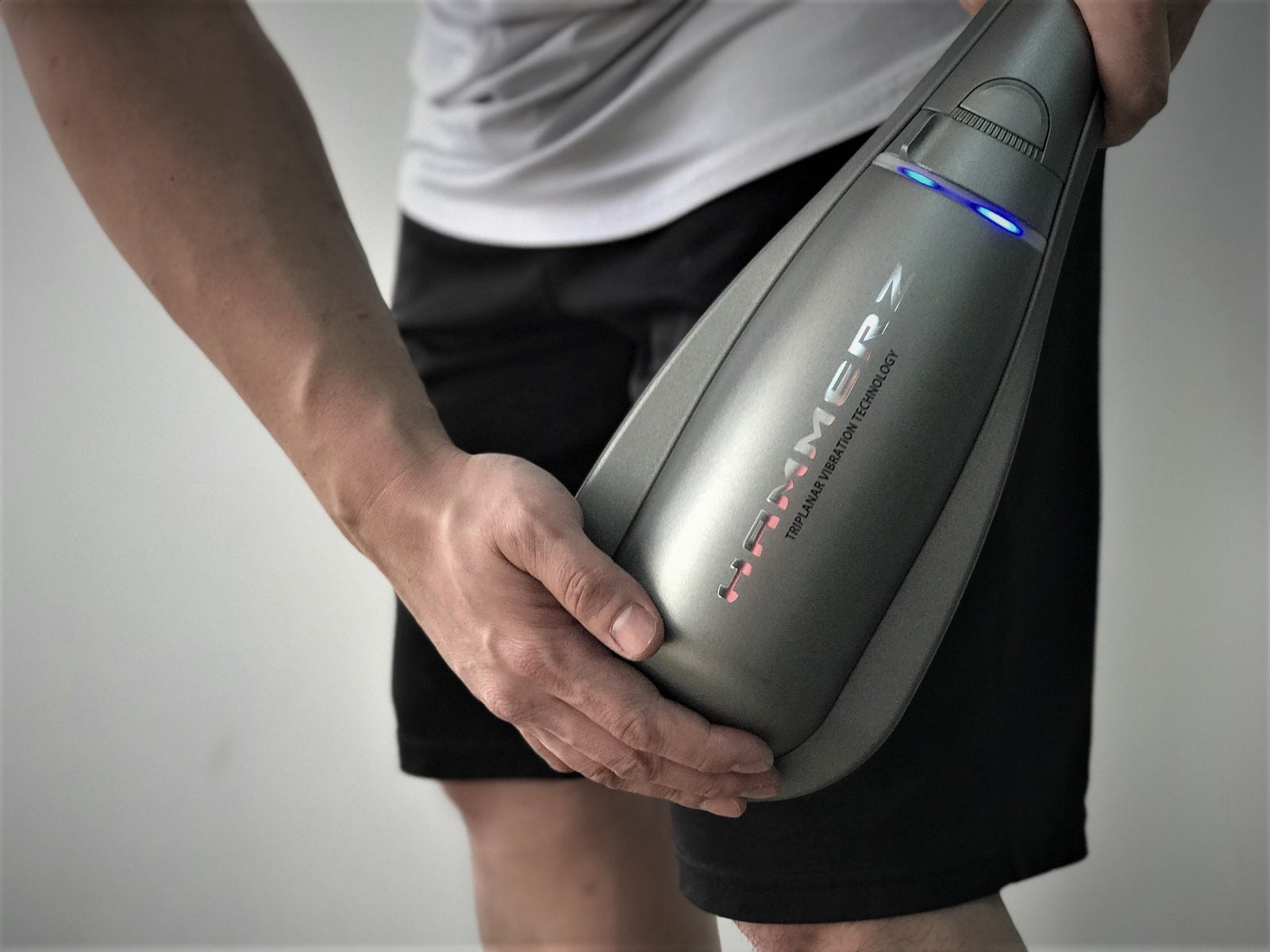 HAMMERZ MASSAGE DEVICE WITH TRIPLANAR VIBRATION TECHNOLOGY — Man using the massager on his quad