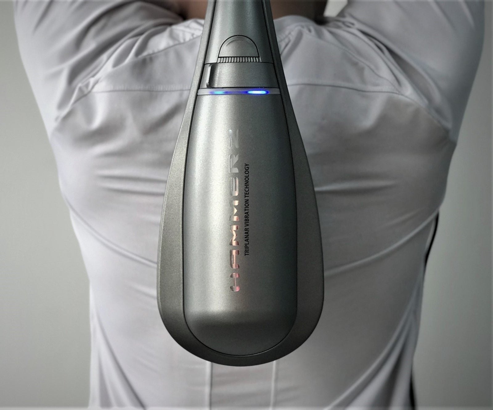 HAMMERZ MASSAGE DEVICE WITH TRIPLANAR VIBRATION TECHNOLOGY — person using the Hammerz massager on their upper back